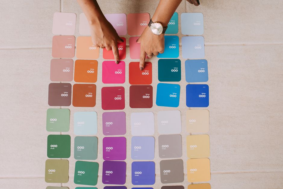 A collection of paint swatch cards shows various shades of exterior house paint.