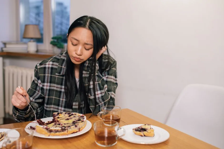 A slice of blueberry pie sits on a plate next to a fork.