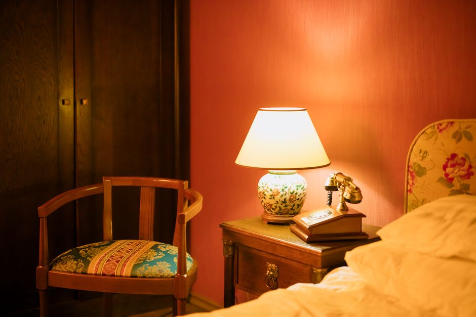 A motel room with vintage furniture and a window air conditioning unit.